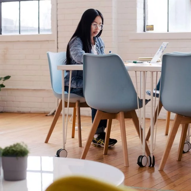 Woman sitting at a table working on a laptop